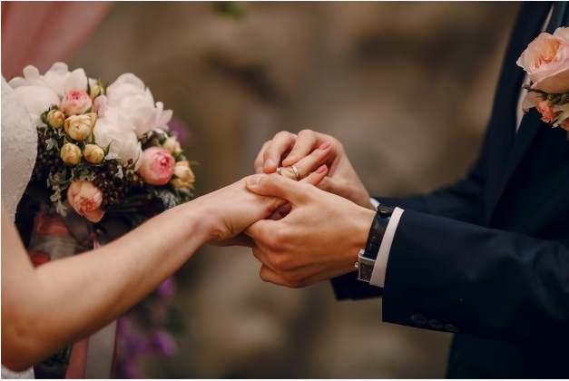 noivo colocando aliança na mão da noiva