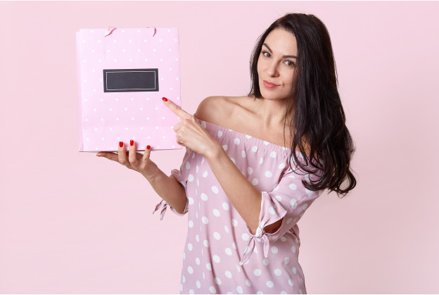 mulher segurando uma sacola personalizada no presente na cor rosa
